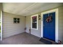 Inviting front porch with a blue door, festive decor, and a cozy, welcoming ambiance at 1330 Ne 55Th St, Ocala, FL 34479