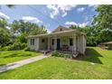 Attractive home features a quaint covered porch with a bench and a lush green lawn at 1330 Ne 55Th St, Ocala, FL 34479
