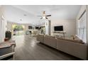Open-concept living room seamlessly blends with a kitchen, complete with modern furniture and abundant natural light at 13479 Sw 100Th Ln, Dunnellon, FL 34432