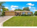 Beautiful one-story home featuring a well-manicured lawn and mature landscaping with a paved driveway at 13835 Se 85Th Cir, Summerfield, FL 34491