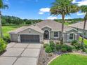 Beautiful home showcasing lush landscaping, mature palm trees, and well-maintained lawn at 1443 Sw 161St St, Ocala, FL 34473