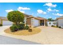 Charming home featuring an attached two car garage and a well maintained front yard with decorative landscaping at 1751 Brandenburg Ct, The Villages, FL 32163