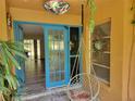 Charming front entrance with blue double doors, unique lighting, and a hanging chair at 20045 Sw 88Th Place Rd, Dunnellon, FL 34431