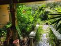 Beautiful walkway with stone benches and a decorative archway, surrounded by lush plants at 20045 Sw 88Th Place Rd, Dunnellon, FL 34431