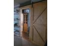 Rustic bathroom with barn door, wood shelving, and an accent light fixture at 2312 Ne 37Th St, Ocala, FL 34479