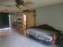 Comfortable living room featuring a daybed, industrial shelving and sliding barn door to the bathroom at 2312 Ne 37Th St, Ocala, FL 34479