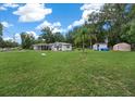 Expansive grassy yard with a white single-story house, storage, and serene country atmosphere at 2340 Ne 14Th Ave, Ocala, FL 34470