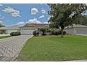 Beautiful single-story home with lush green lawn and brick driveway at 3146 Williams Rd, The Villages, FL 32162
