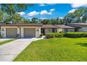 Inviting townhome featuring a manicured lawn, charming landscaping, and attached garages at 3707 Ne 17Th St, Ocala, FL 34470