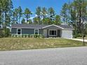 Charming home featuring a manicured lawn, attached one-car garage, and tasteful landscaping at 5185 Sw 158Th Pl, Ocala, FL 34473