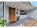 Close up of front door adorned with charming accents, alongside decorative plants, creating a welcoming entrance at 5500 Se 2Nd Pl, Ocala, FL 34480