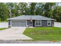 Charming single-story home with a well-maintained lawn and a two-car garage at 6 Sequoia Loop, Ocklawaha, FL 32179