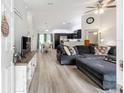 Open-concept living room with hardwood floors, modern furnishings, and lots of natural light at 6 Sequoia Loop, Ocklawaha, FL 32179