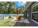 Cozy backyard patio with pool, lounge chairs, and umbrella, great for entertaining at 6 Sequoia Loop, Ocklawaha, FL 32179