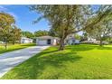 Inviting single-story home with a lush green lawn and mature trees at 6113 Sw 101St Pl, Ocala, FL 34476