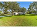 Inviting single-story home with a lush green lawn and mature trees at 6113 Sw 101St Pl, Ocala, FL 34476