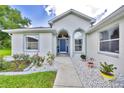 Close-up of the home's entrance features an elegant blue door, arched windows and stone landscaping at 6330 Sw 117Th Loop, Ocala, FL 34476