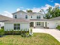 Inviting two-story home with a well-maintained lawn, lush landscaping, and a covered front porch at 7067 Sw 60Th Ln, Ocala, FL 34474
