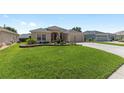 Well-manicured lawn and neutral stucco highlight the exterior of this lovely home at 7243 Se 172Nd Legacy Ln, The Villages, FL 32162