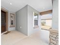 Inviting front porch featuring decorative stone columns, neutral walls and trimmed windows at 7454 Sw 101St Ave, Ocala, FL 34481
