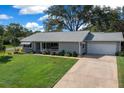 An elevated shot of a cozy home with a well-kept lawn and driveway leading to a two-car garage at 8461 Sw 109Th St, Ocala, FL 34481