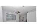 Bright living room with a ceiling fan and a large window offering plenty of natural light at 8775 Sw 192 Ct, Dunnellon, FL 34432