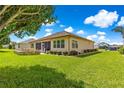 Spacious backyard showcasing a patio area with ample seating, a stone firepit, and lush green grass at 9120 Se 125Th Loop, Summerfield, FL 34491