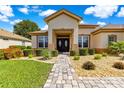 Inviting front entrance featuring a brick walkway leading to a double-door entry and manicured landscaping at 9120 Se 125Th Loop, Summerfield, FL 34491