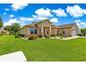 Beautifully landscaped home with green lawn, mature shrubs, and a two-car garage and ample natural light at 9120 Se 125Th Loop, Summerfield, FL 34491