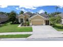 Inviting single-story home with a manicured lawn and mature landscaping, showcasing a convenient two-car garage and classic design at 9948 Sw 69Th Ln, Ocala, FL 34481
