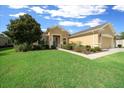Charming single-story house with a well-kept lawn and landscaping, plus a sidewalk leading to the front door at 9948 Sw 69Th Ln, Ocala, FL 34481