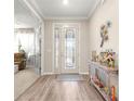 Welcoming foyer with decorative glass door, wood-look flooring, and a view into the living area at 10597 Sw 90Th Street Rd, Ocala, FL 34481