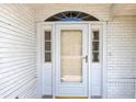 Close-up of the front door featuring glass sidelights and transom window on a brick facade at 10819 Sw 84Th Ter, Ocala, FL 34481
