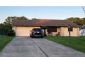 Inviting single-story home showcasing a well-manicured lawn and a paved driveway leading to a two-car garage at 10885 Se 74Th Ct, Belleview, FL 34420
