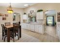 Open-concept kitchen with white cabinets, modern appliances, and an adjacent dining area at 12178 Se 174Th Pl, Summerfield, FL 34491