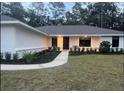 Welcoming home with a modern walkway and neatly manicured landscaping leading to the front door at 1245 Nw 73Rd Ter, Ocala, FL 34482
