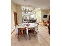 Cozy dining area featuring tile flooring and a chandelier with views into the kitchen and living room at 13506 Sw 43Rd Cir, Ocala, FL 34473