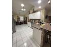 Bright kitchen featuring tiled floors, granite countertops, stainless steel appliances, and breakfast bar at 13506 Sw 43Rd Cir, Ocala, FL 34473