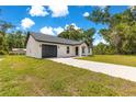 Front yard view of a charming single-story home with an attached garage at 14876 Se 34Th Ter, Summerfield, FL 34491