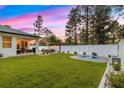 Expansive backyard with a fenced perimeter, featuring a cozy covered patio and an in-ground spa at 155 Marion Oaks Pass, Ocala, FL 34473