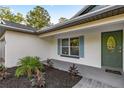 Inviting front porch with a beautiful door, blue shutters, and lovely landscaping at 158 Guava Pass, Ocklawaha, FL 32179
