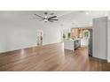 Spacious open-concept living area with wood floors, modern ceiling fan, and ample natural light at 158 Guava Pass, Ocklawaha, FL 32179
