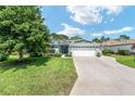Charming single-story home with a well-manicured lawn and a three-car garage at 16023 Sw 14Th Avenue Rd, Ocala, FL 34473