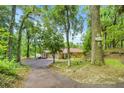 Serene setting of home among mature trees, with a winding driveway, and view of the lake at 19620 Fox Trl, Dunnellon, FL 34432