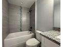 Bathroom showcasing a bathtub with tiled walls and a modern vanity with a granite countertop at 19990 Sw 75Th St, Dunnellon, FL 34431