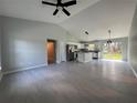 Open-concept living space features vaulted ceilings, gray tile flooring, and a kitchen island with modern appliances at 19990 Sw 75Th St, Dunnellon, FL 34431