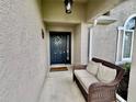 Close-up of the front door, showcasing a charming wreath and a cozy bench at 2100 Nw 50Th Cir, Ocala, FL 34482