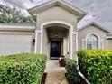 Inviting front porch area with a charming black door and decorative wreath at 2100 Nw 50Th Cir, Ocala, FL 34482
