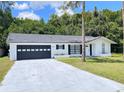 Charming single-story home featuring a well-maintained lawn and a spacious two-car garage at 21111 Sw Honeysuckle St, Dunnellon, FL 34431