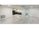 Spacious open-concept living room featuring white marble floors and modern recessed lighting at 21111 Sw Honeysuckle St, Dunnellon, FL 34431
